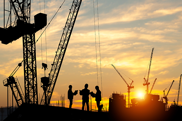 Silhouette of Engineer and worker team on building site, construction site at sunset in evening time